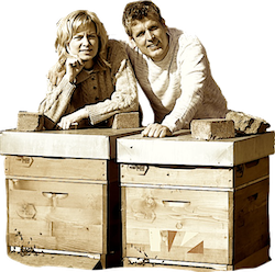Imkerpaar Wöll lehnt gemeinsam auf einer Bienenkiste